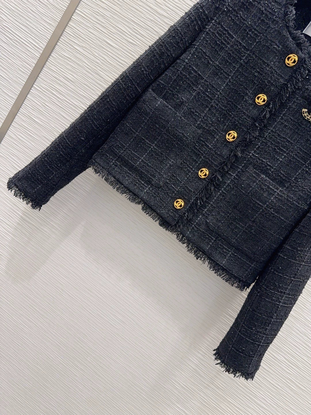 26Long-sleeved, round-neck, single-breasted jacket featuring a decorative brooch and tasseled pockets