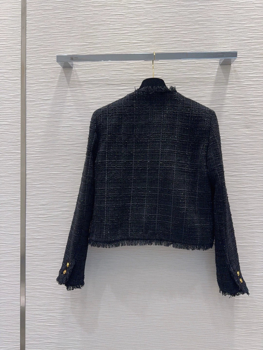 26Long-sleeved, round-neck, single-breasted jacket featuring a decorative brooch and tasseled pockets