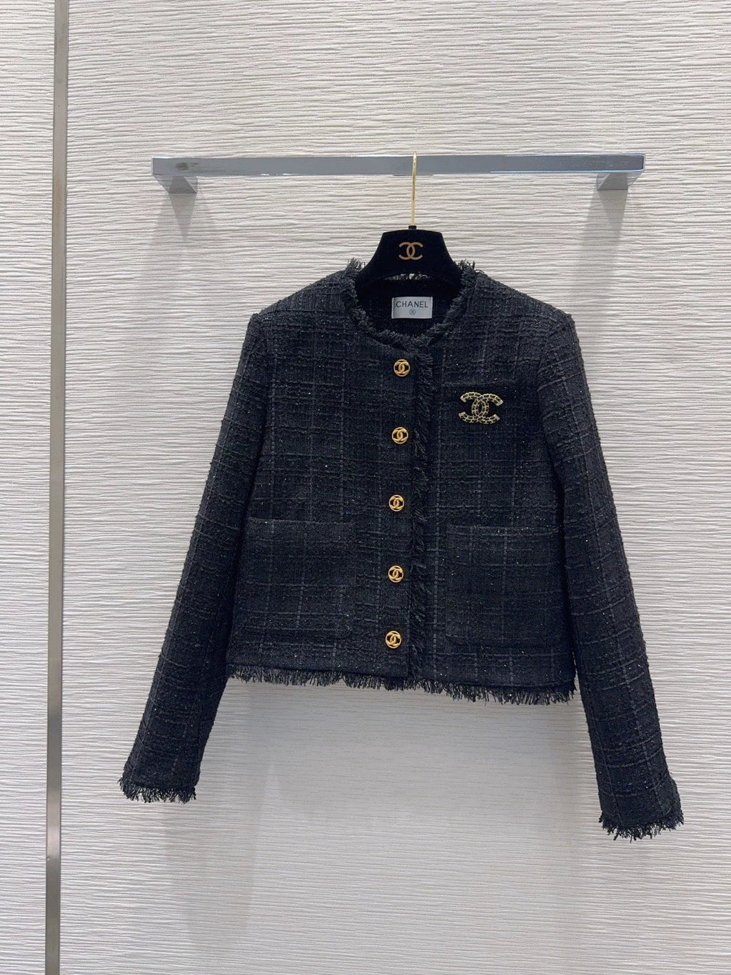 26Long-sleeved, round-neck, single-breasted jacket featuring a decorative brooch and tasseled pockets