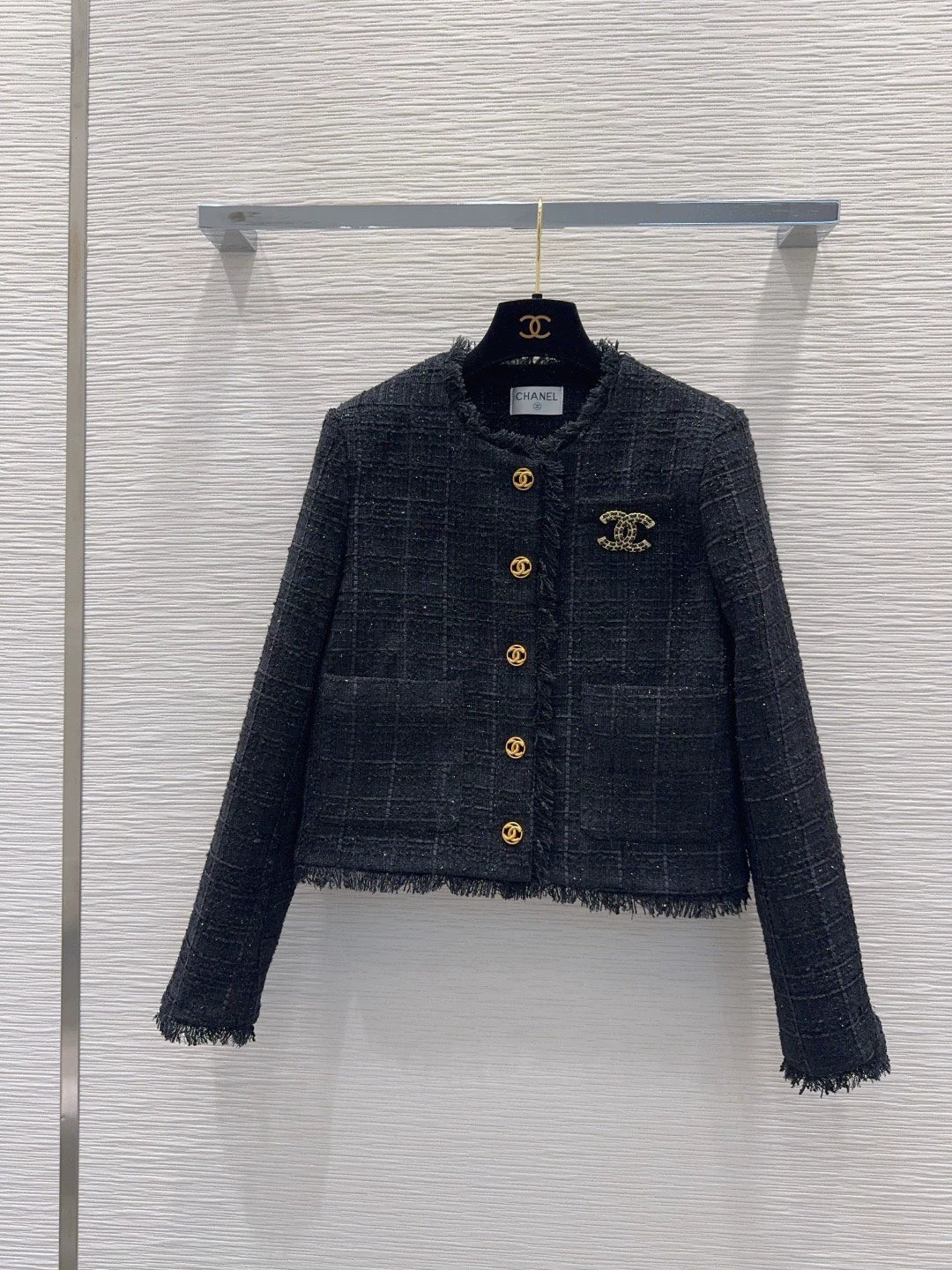 26Long-sleeved, round-neck, single-breasted jacket featuring a decorative brooch and tasseled pockets